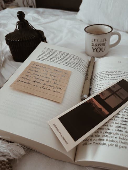 An open book with a bookmark and a cup, suggesting a cozy reading atmosphere.