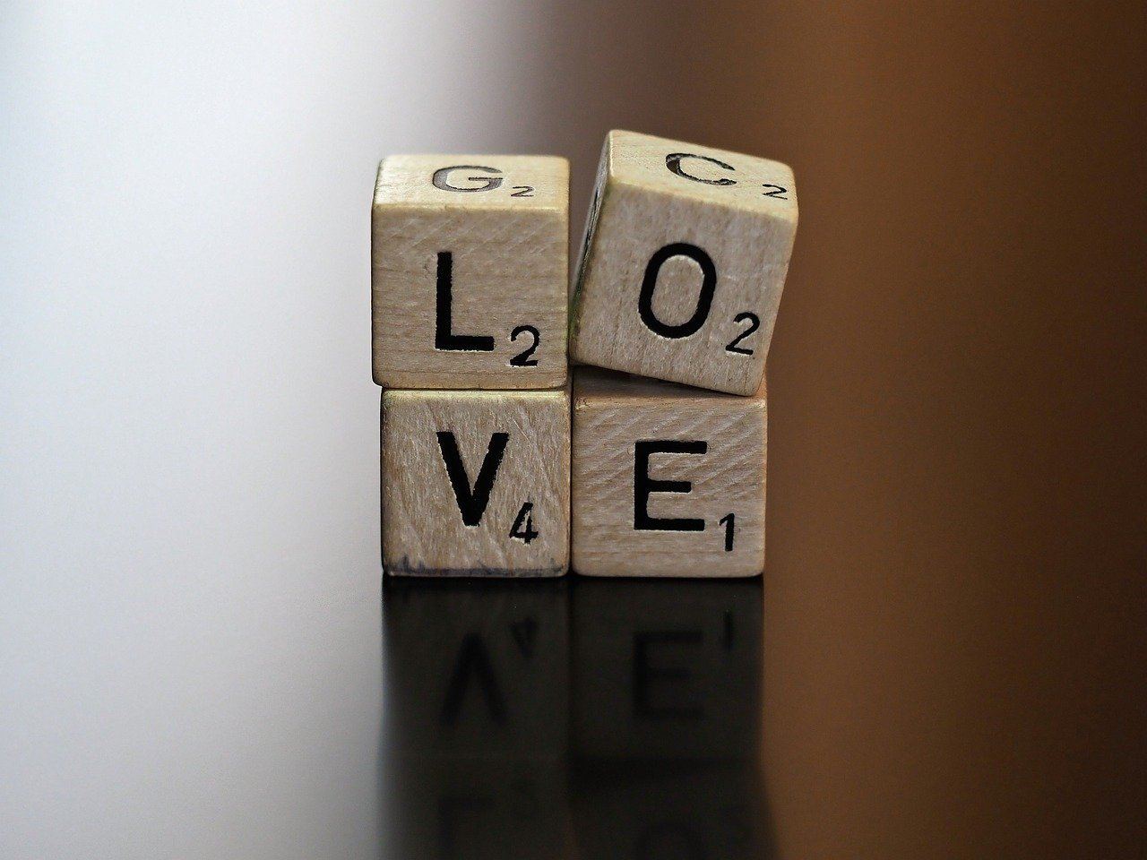 Wooden letter tiles spelling 'LOVE', representing wordplay in Scrabble. Is Scrabble for you? Let's find out!