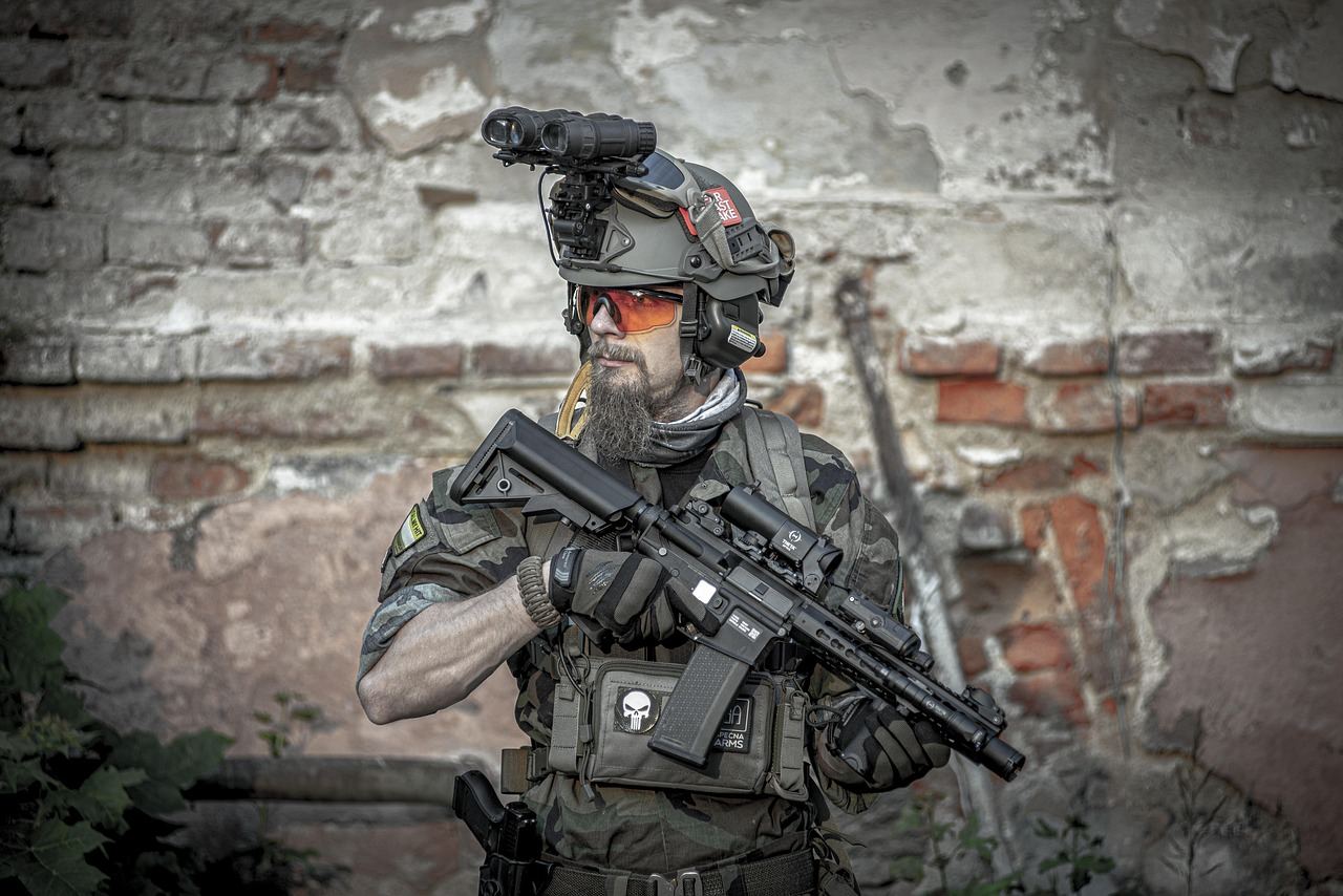 A group of players in tactical gear strategizes behind cover during an intense airsoft match in a wooded area.