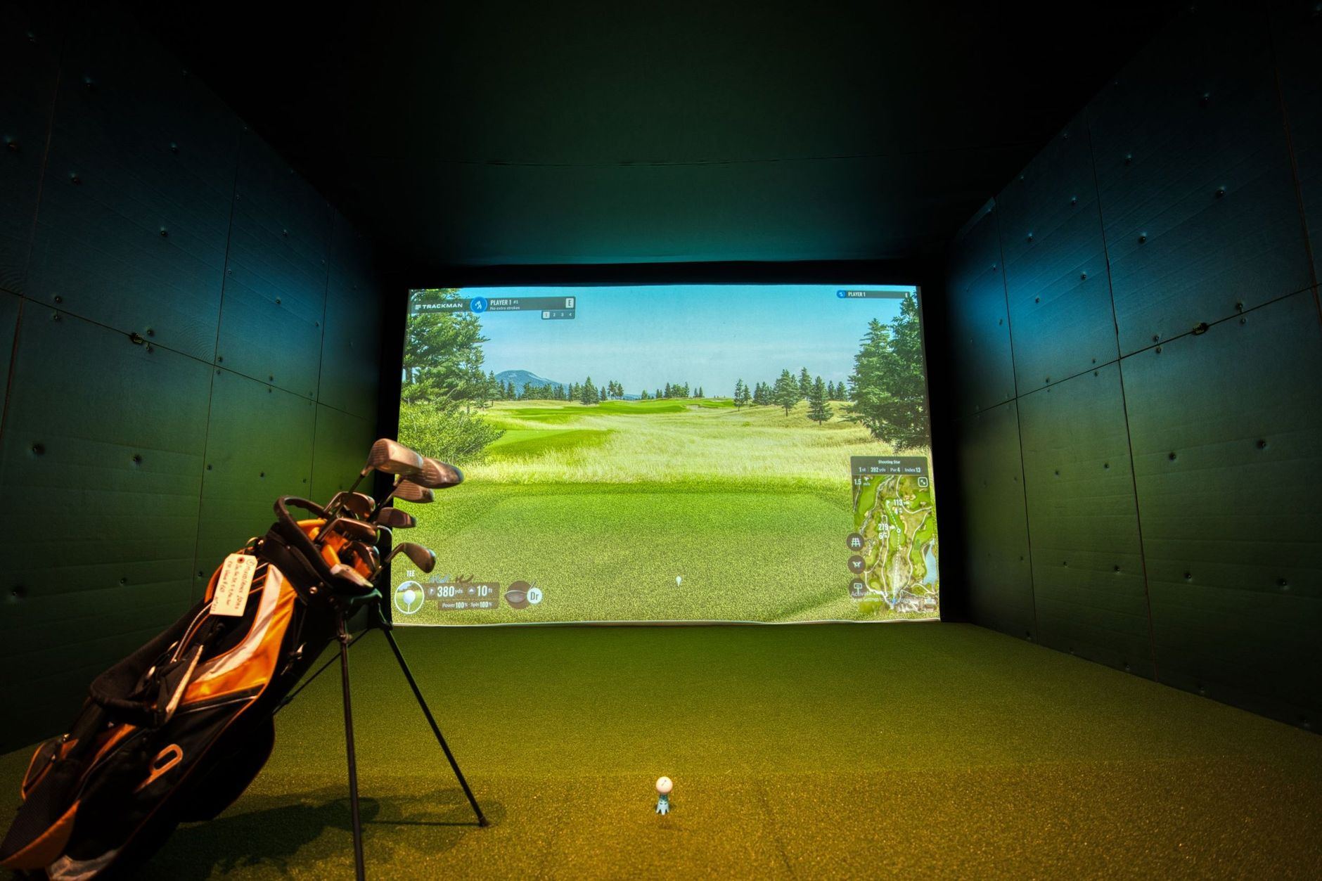 A sleek indoor golf simulator featuring vibrant course graphics, set in a contemporary facility in Mississauga, Canada.
