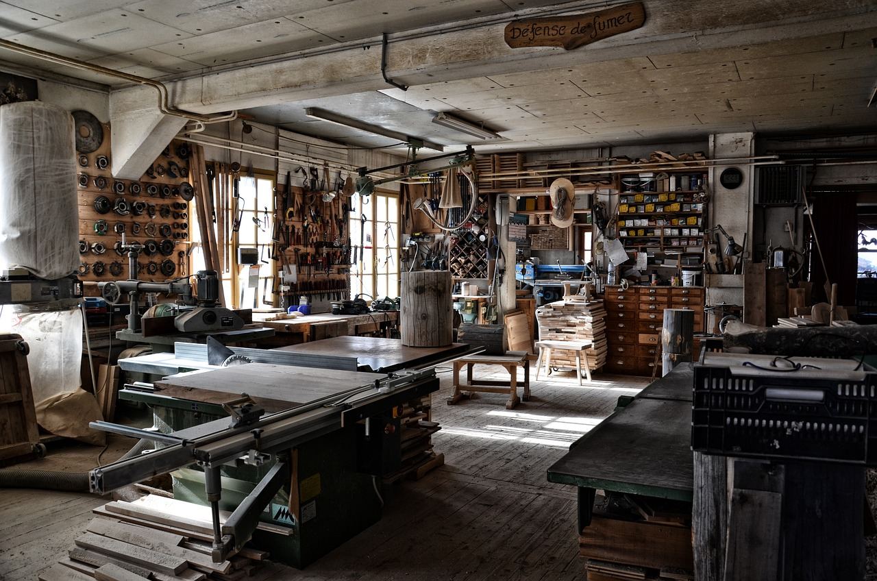 A cozy workshop filled with tools and materials for bookbinding, showcasing a table cluttered with colorful papers and binding supplies.