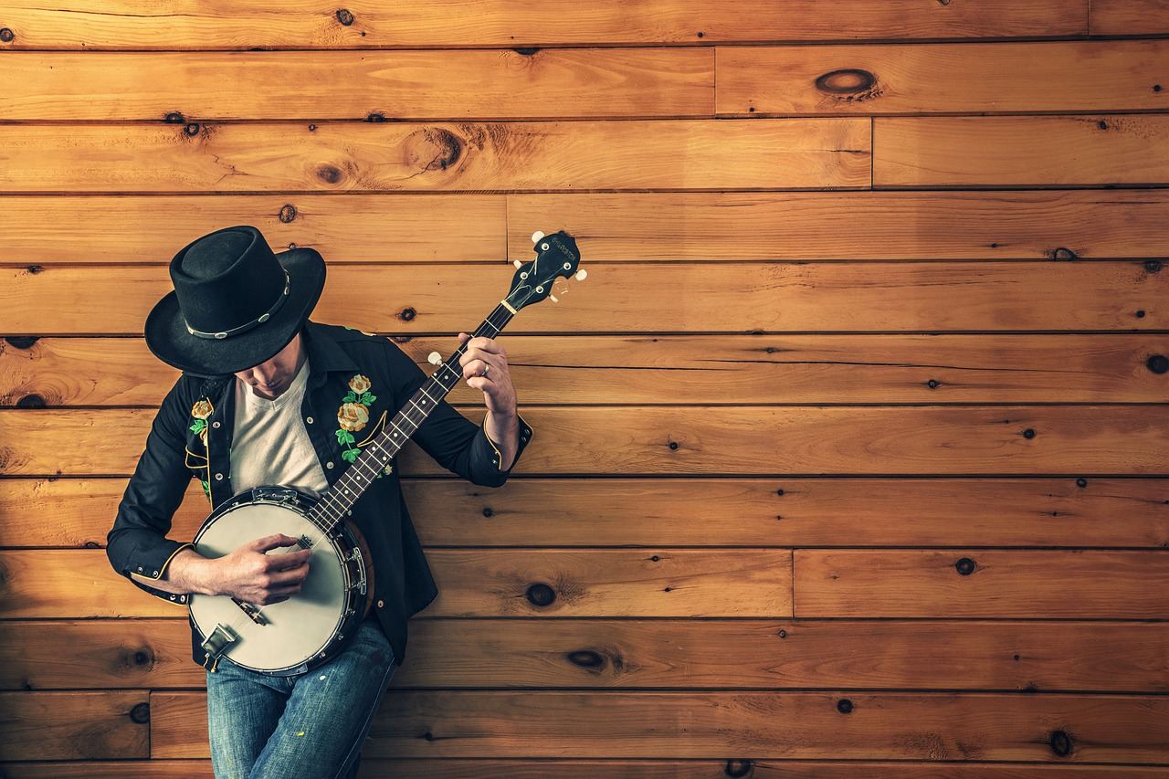 A musician plays a banjo against a wooden wall, embodying the spirit of 'Is Banjo for you? Let's find out!'