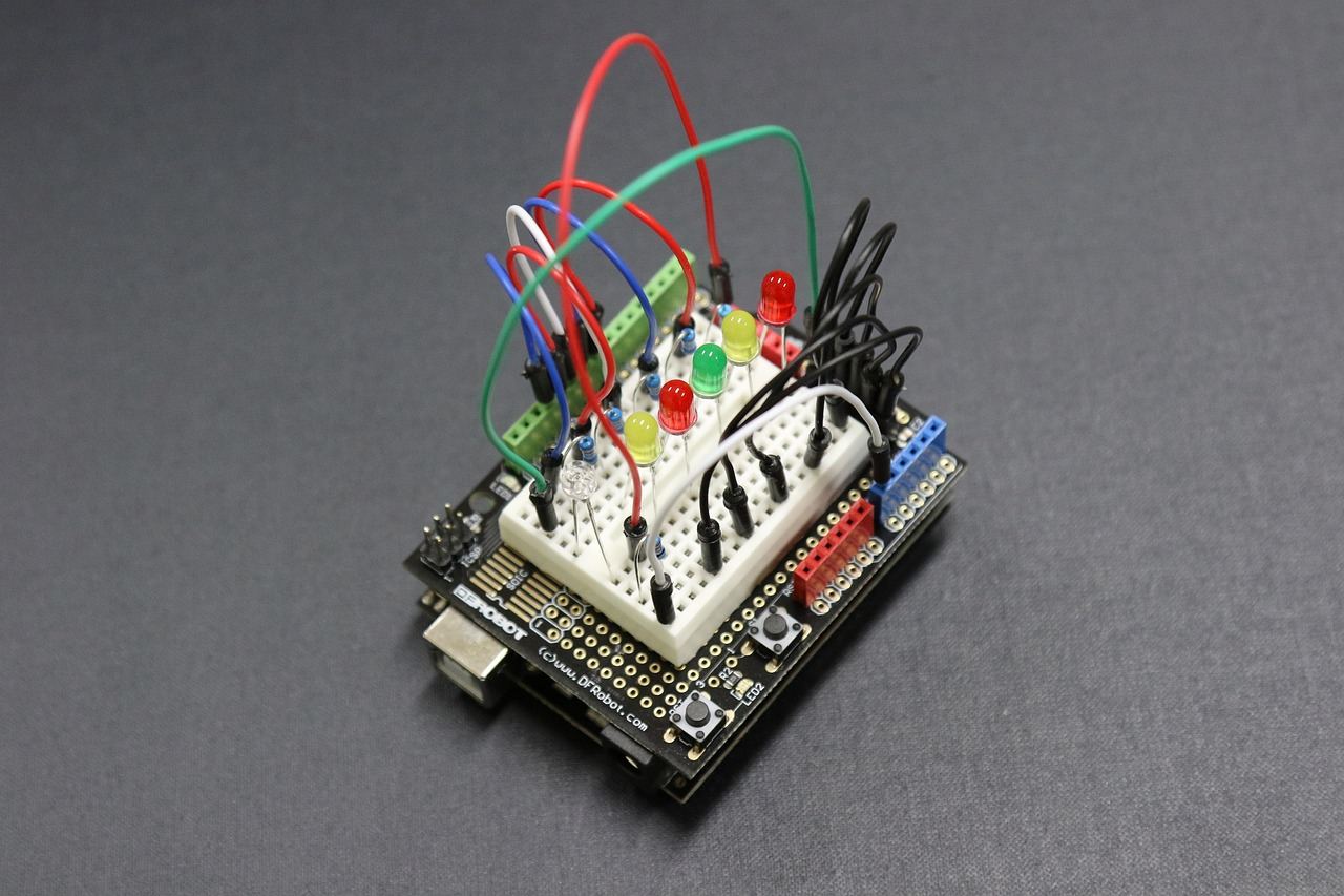 A close-up of an Arduino board surrounded by colorful wires and electronic components, showcasing a creative DIY project setup.