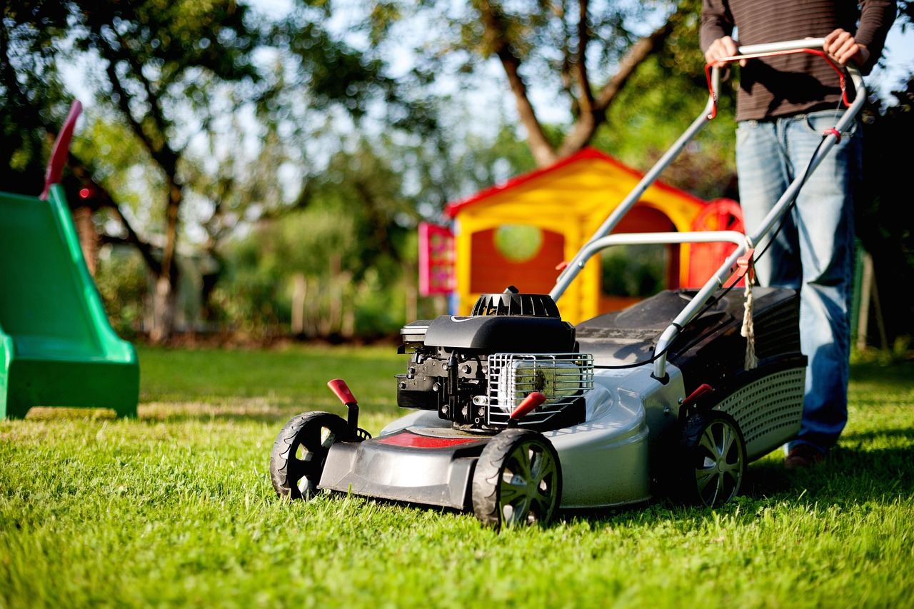 A person mows a green lawn with a lawn mower, exploring if lawn care is for you. Let's find out!