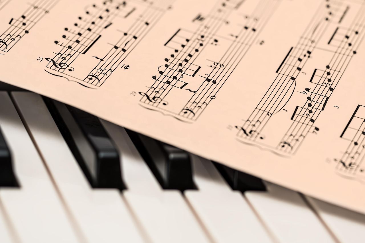 A grand piano with polished black keys glistening under soft lighting, inviting creativity and musical expression.