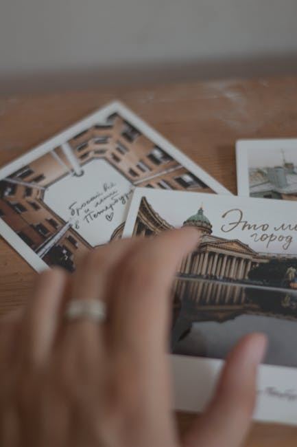 A hand reaching for postcards featuring cityscapes, suggesting a theme of postcard collecting.