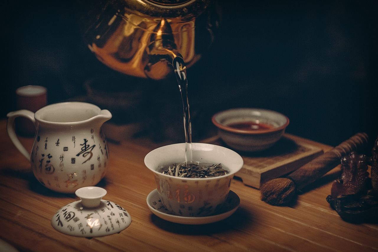 A vibrant assortment of loose-leaf teas, herbs, and spices arranged artfully on a wooden surface, inviting exploration and blending.