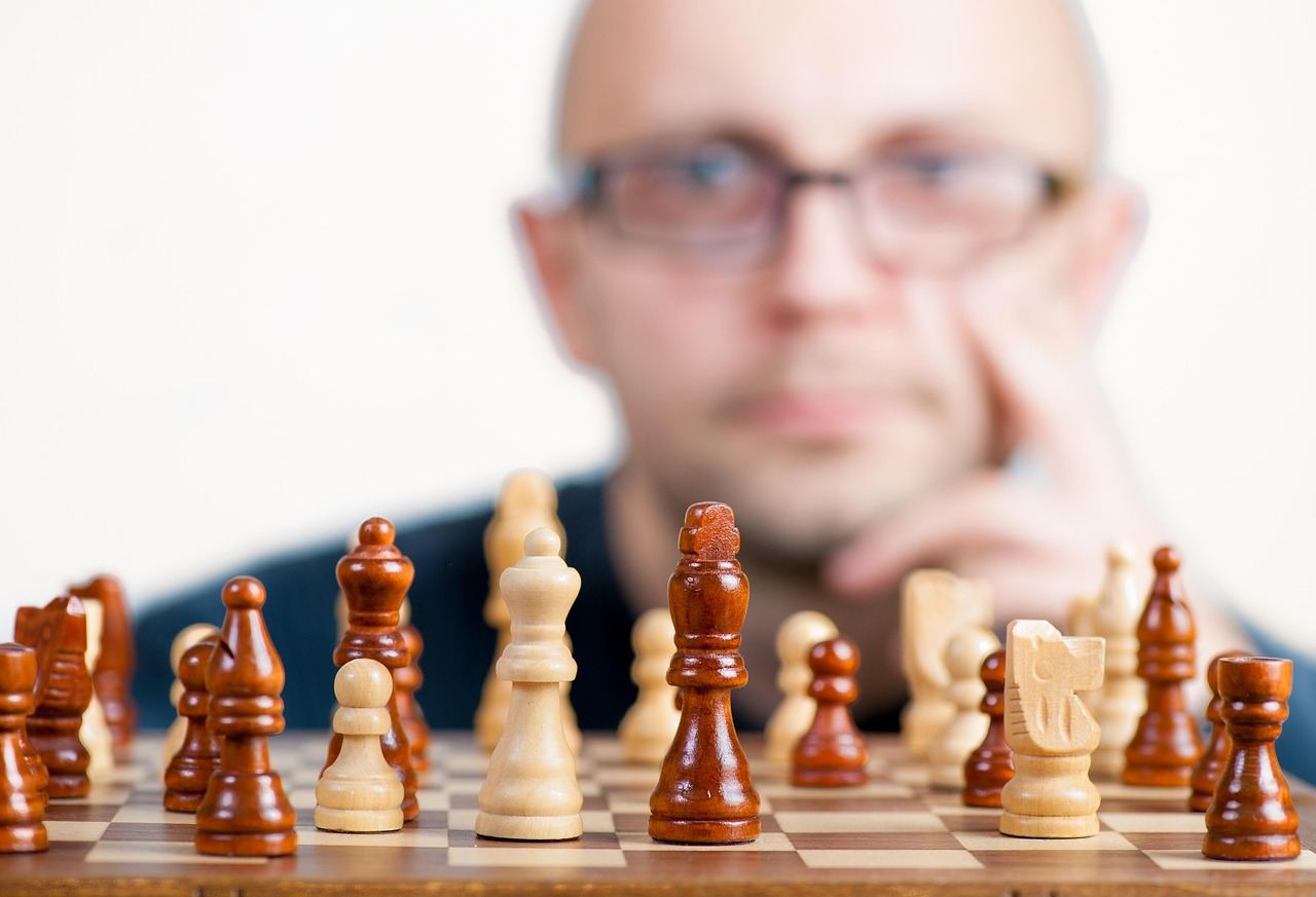 A close-up of a wooden chessboard with intricately carved pieces poised for a strategic match.