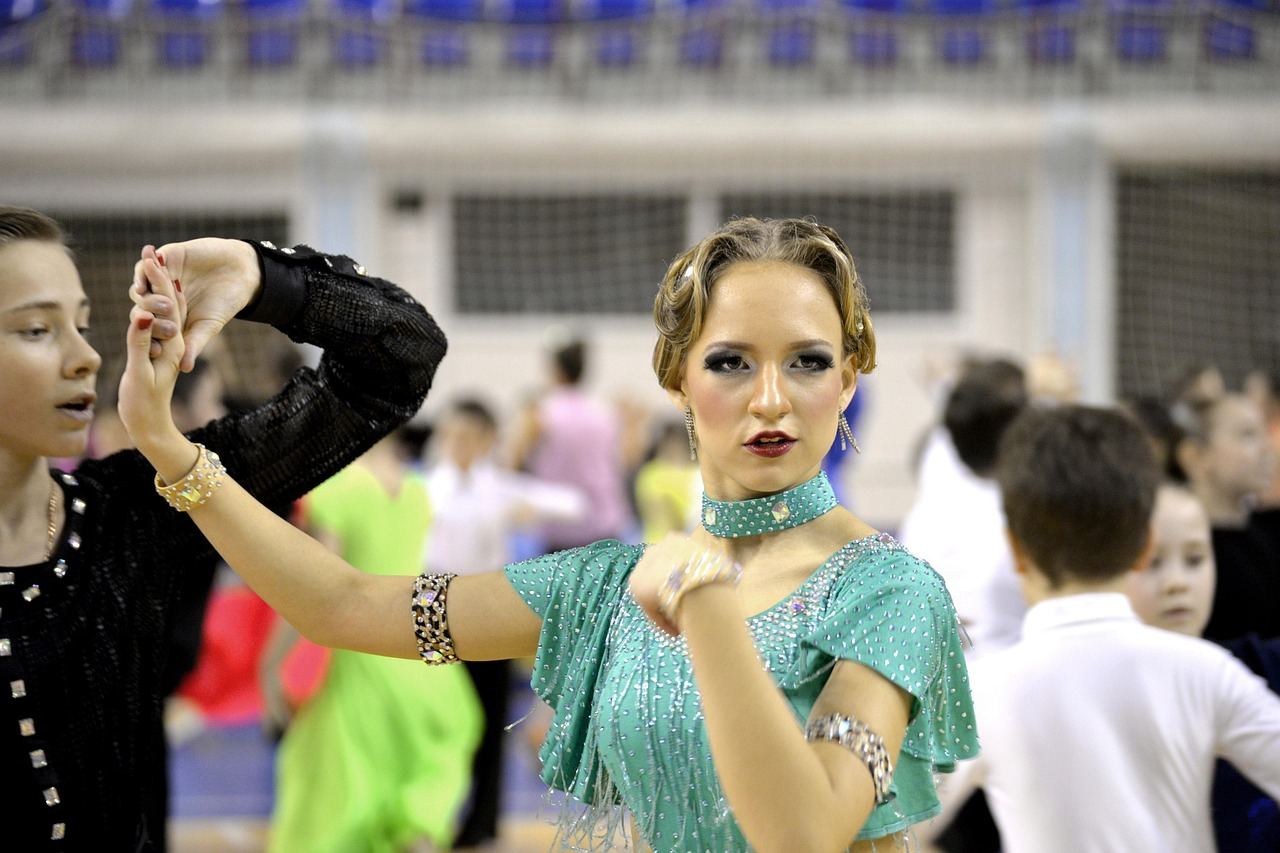 A lively ballroom dance scene featuring elegantly dressed couples twirling gracefully across a polished wooden floor.