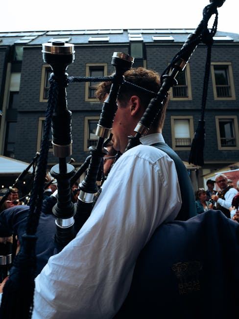 A musician playing bagpipes at an outdoor event, showcasing the instrument and its cultural significance.