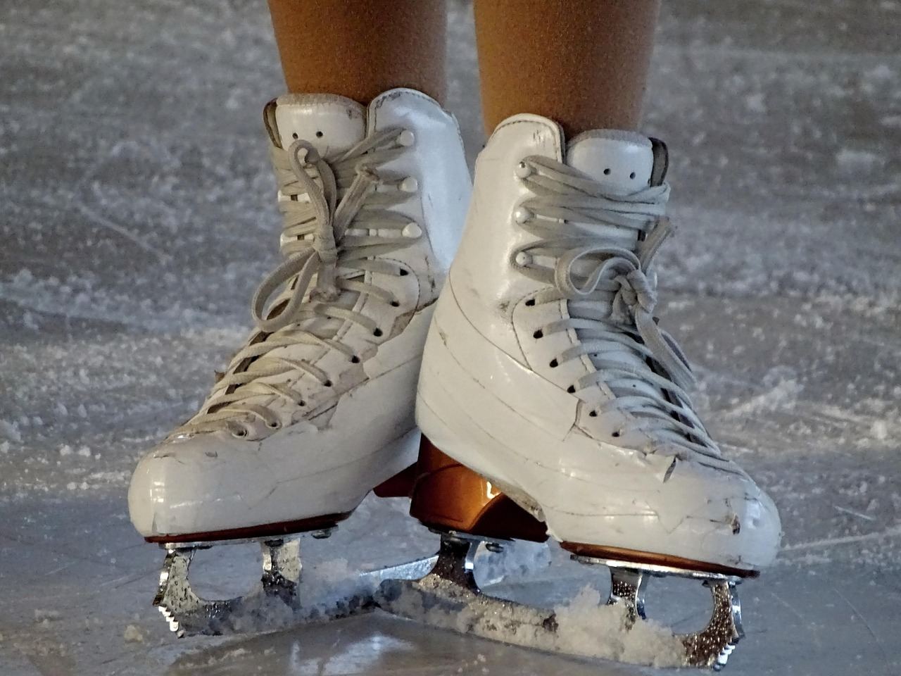 A pair of sleek ice skates resting on a smooth, glistening rink surface, ready for winter fun.