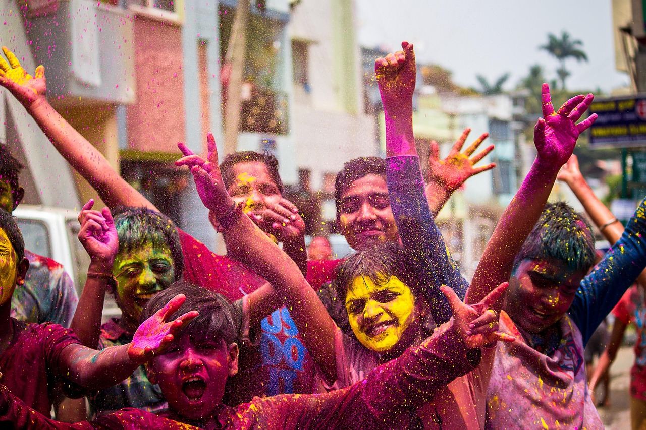 Children joyfully celebrating with colors during a festival, embodying the spirit of festival tourism.