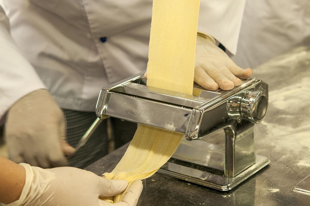 A person using a pasta maker to roll out dough, exploring 'Is Pasta Making for you? Let's find out!'