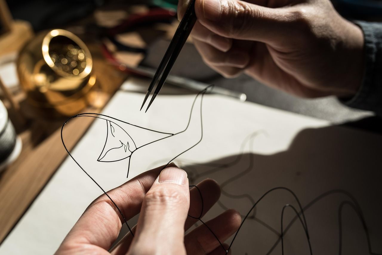 A delicate wire sculpture intricately shaped into a graceful figure, showcasing the artistry of jewelry making.