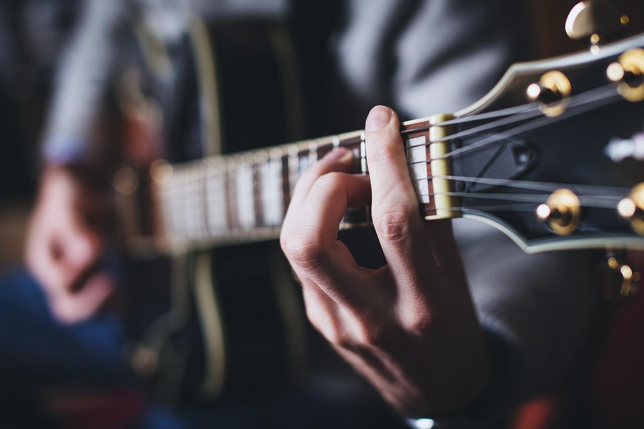 A passionate musician strumming an acoustic guitar, immersed in the rhythm of their music.