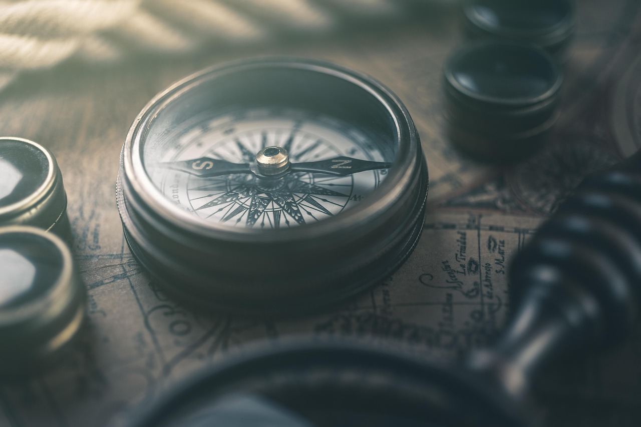 A close-up of a compass resting on a rugged map, symbolizing navigation and adventure in mountain bike orienteering.