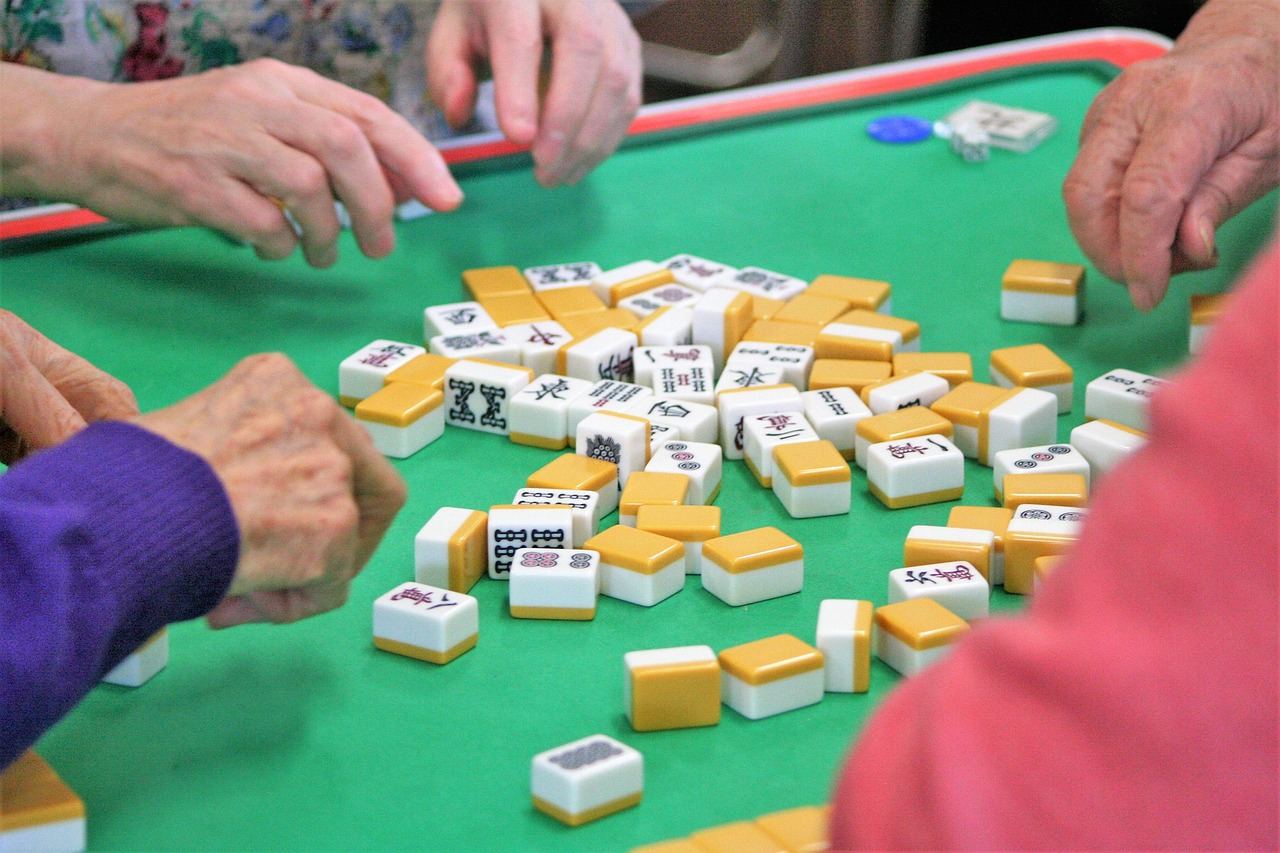 A vibrant mahjong set displayed on a wooden table, featuring intricately designed tiles ready for a game.