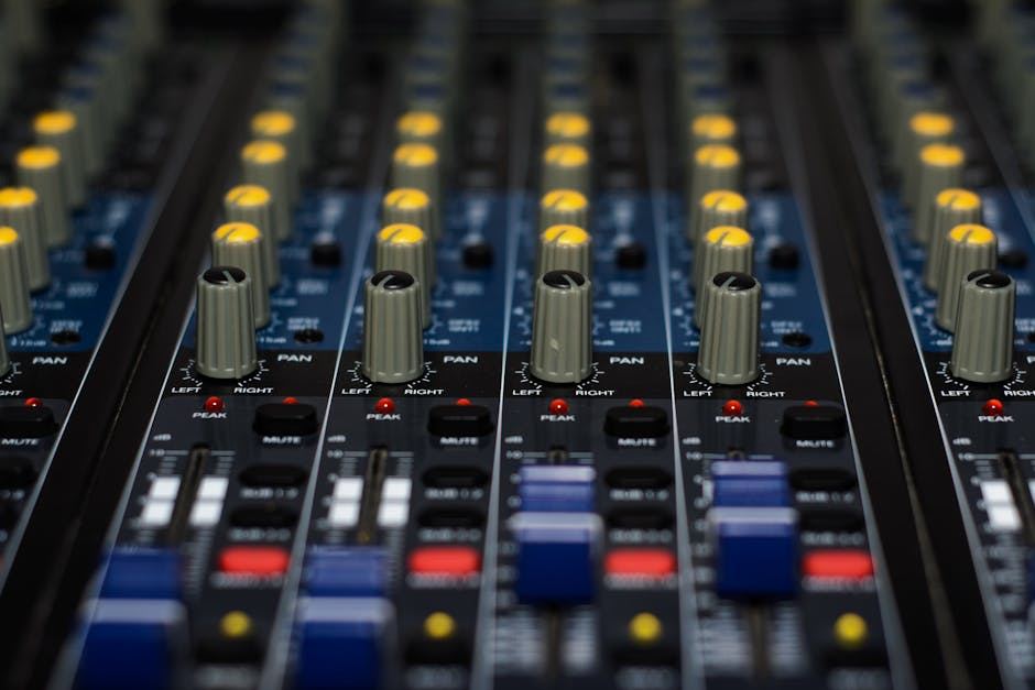 Close-up of a sound mixing console with knobs and buttons, representing sound art and audio production.