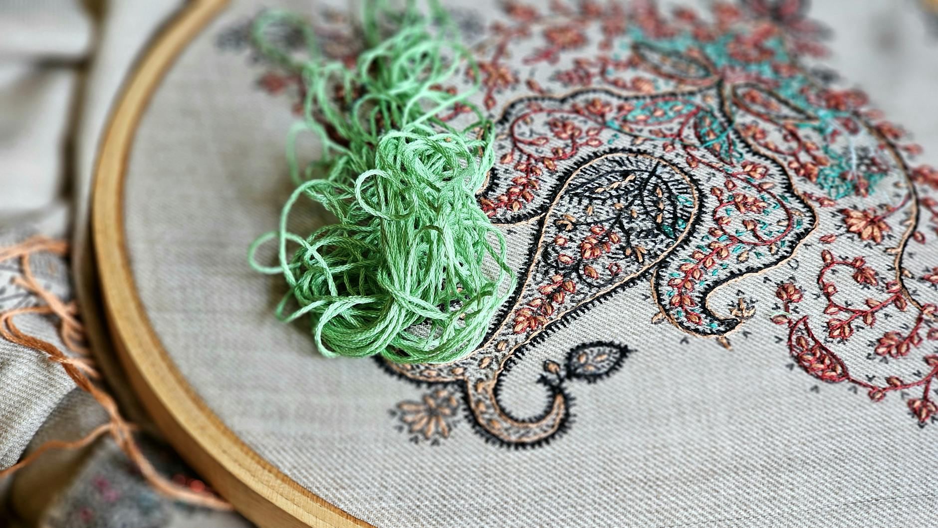 Close-up of vibrant handmade embroidery with colorful threads and wooden hoop.
