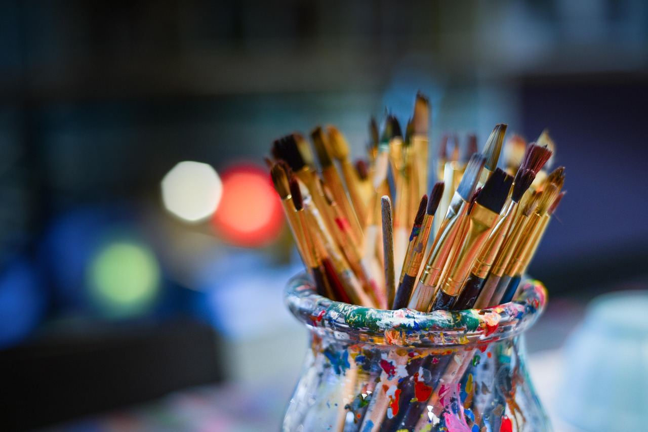 A collection of vibrant paintbrushes arranged artistically, showcasing various sizes and colors, ready for monotype printing.