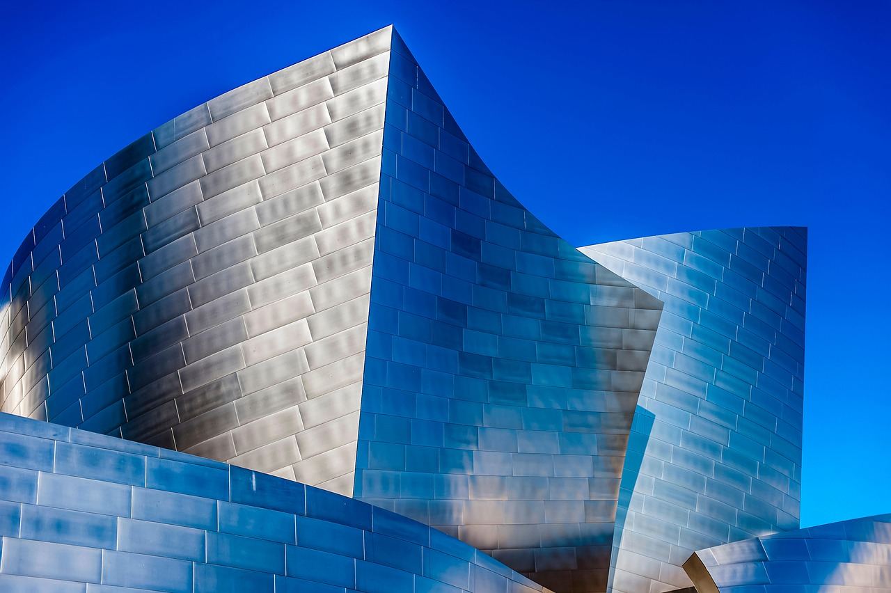 A spacious concert hall featuring elegant seating arrangements and a grand stage, illuminated by soft lighting.