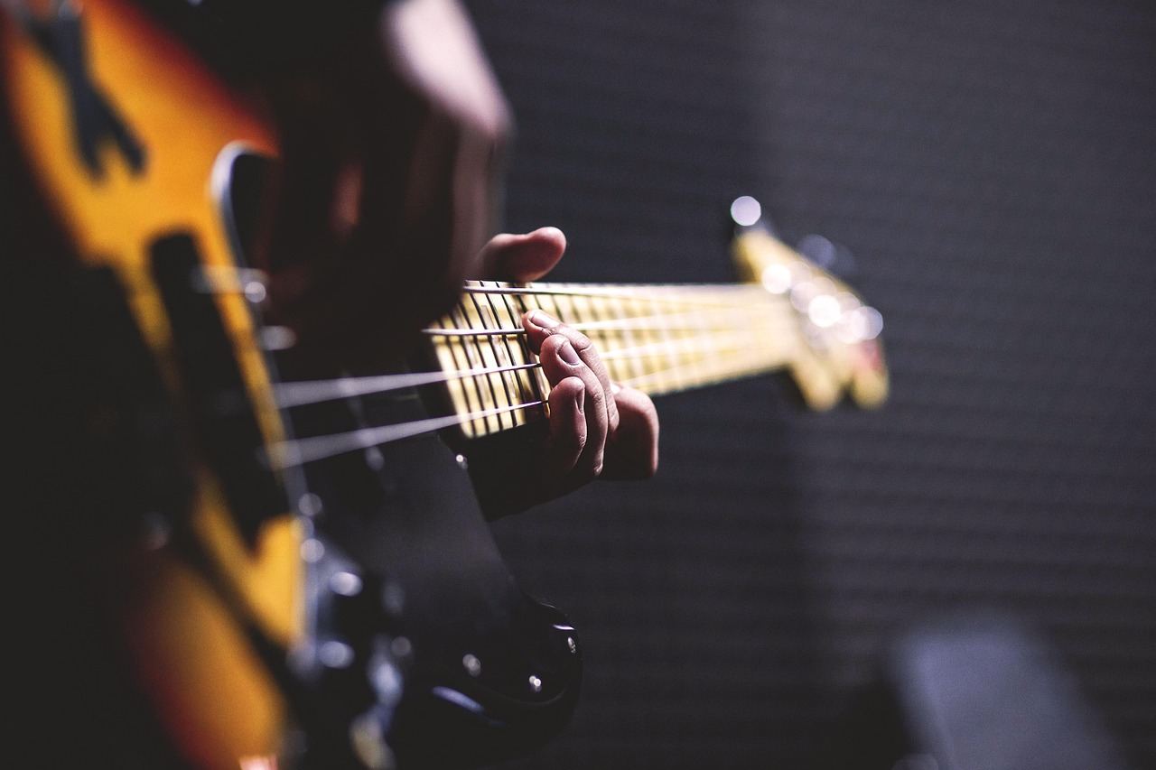 A close-up of a hand playing a bass guitar, perfect for 'Is Bass Guitar for you? Let's find out!'