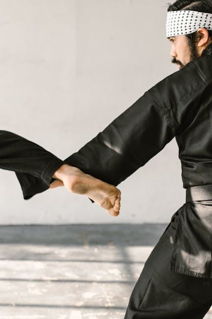 A martial artist in black attire demonstrates a Wing Chun kick technique during practice.