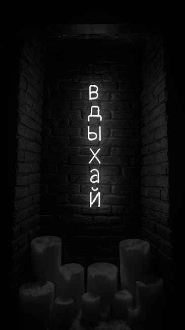 A dark brick wall with the word 'вдыхай' (breathe) illuminated in neon, surrounded by candles.
