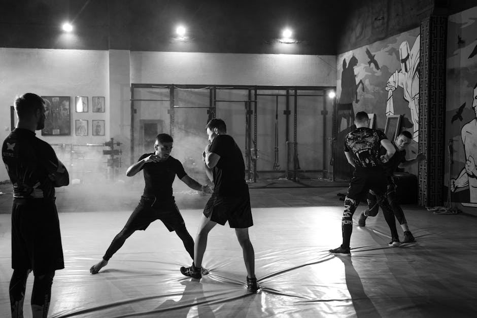 Two fighters practice Sambo techniques in a training facility, showcasing dynamic movement and combat skills.
