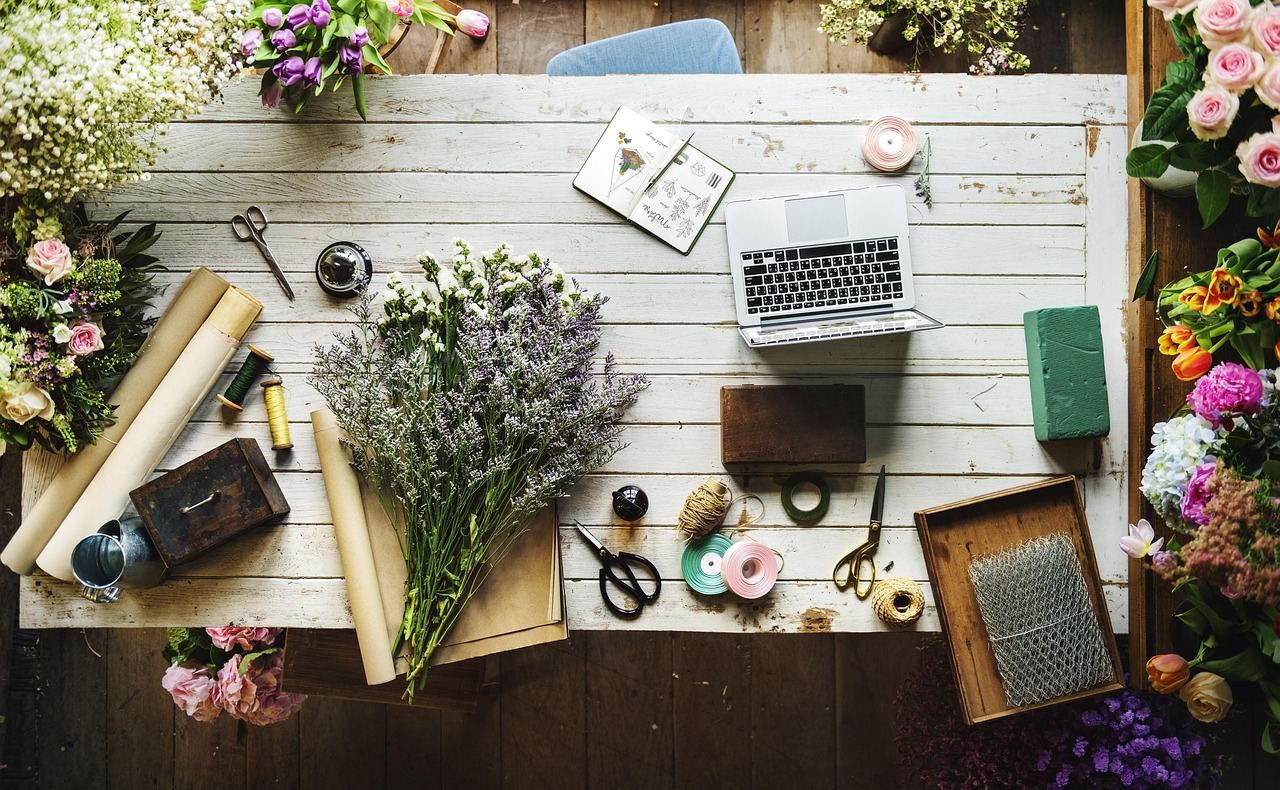 A flower arranging workspace with tools, flowers, and a laptop, perfect for exploring 'Is Flower Arranging for you?'