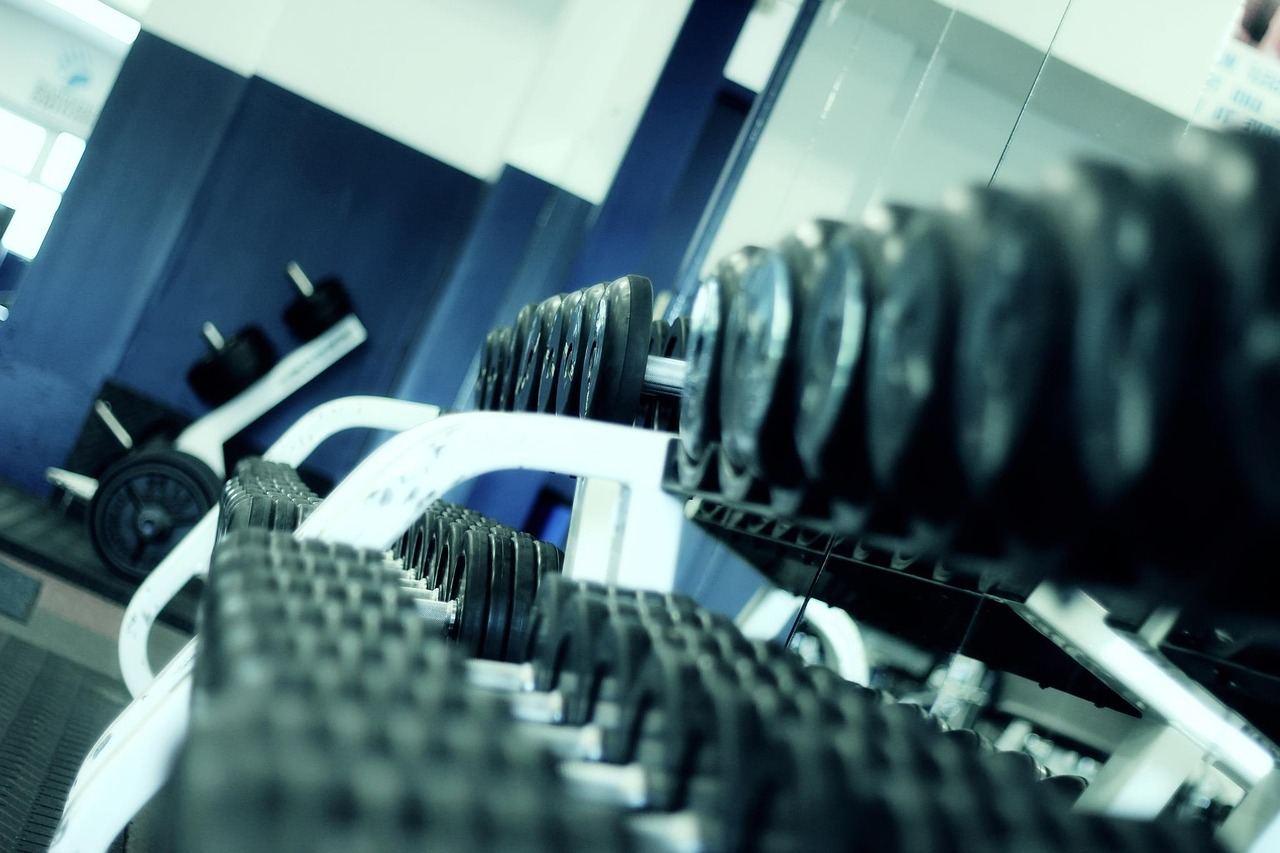 A determined individual performs a deadlift in a gym, showcasing proper form and concentration while lifting a heavy barbell.