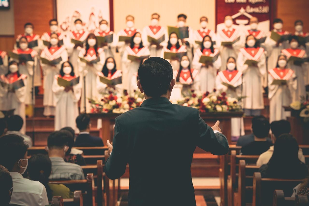 A choir performing under a conductor, showcasing the joy of community singing. Is Choir Singing for you? Let's find out!