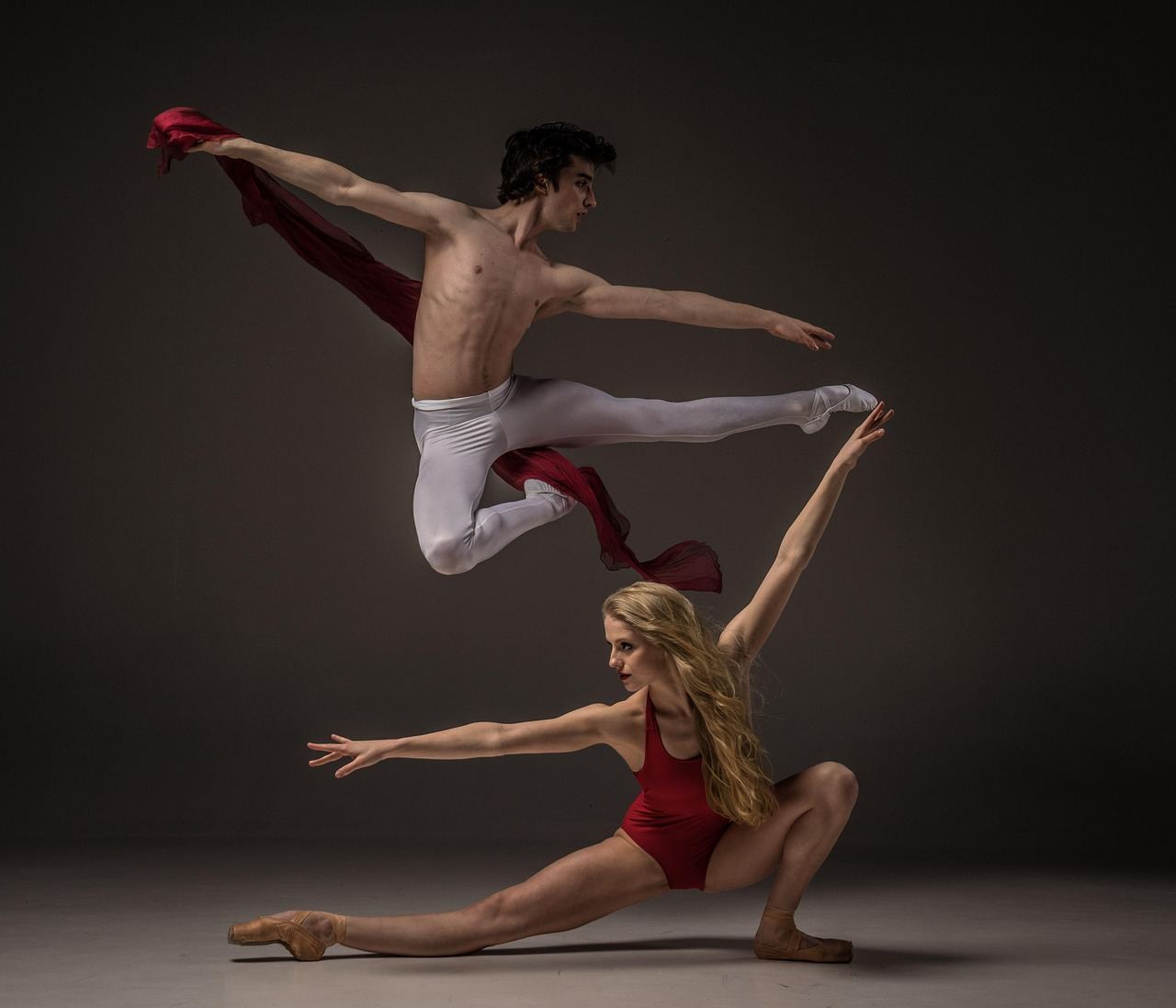 A male ballet dancer leaps while a female dancer poses, embodying the essence of ballet. Is Ballet for you? Let's find o
