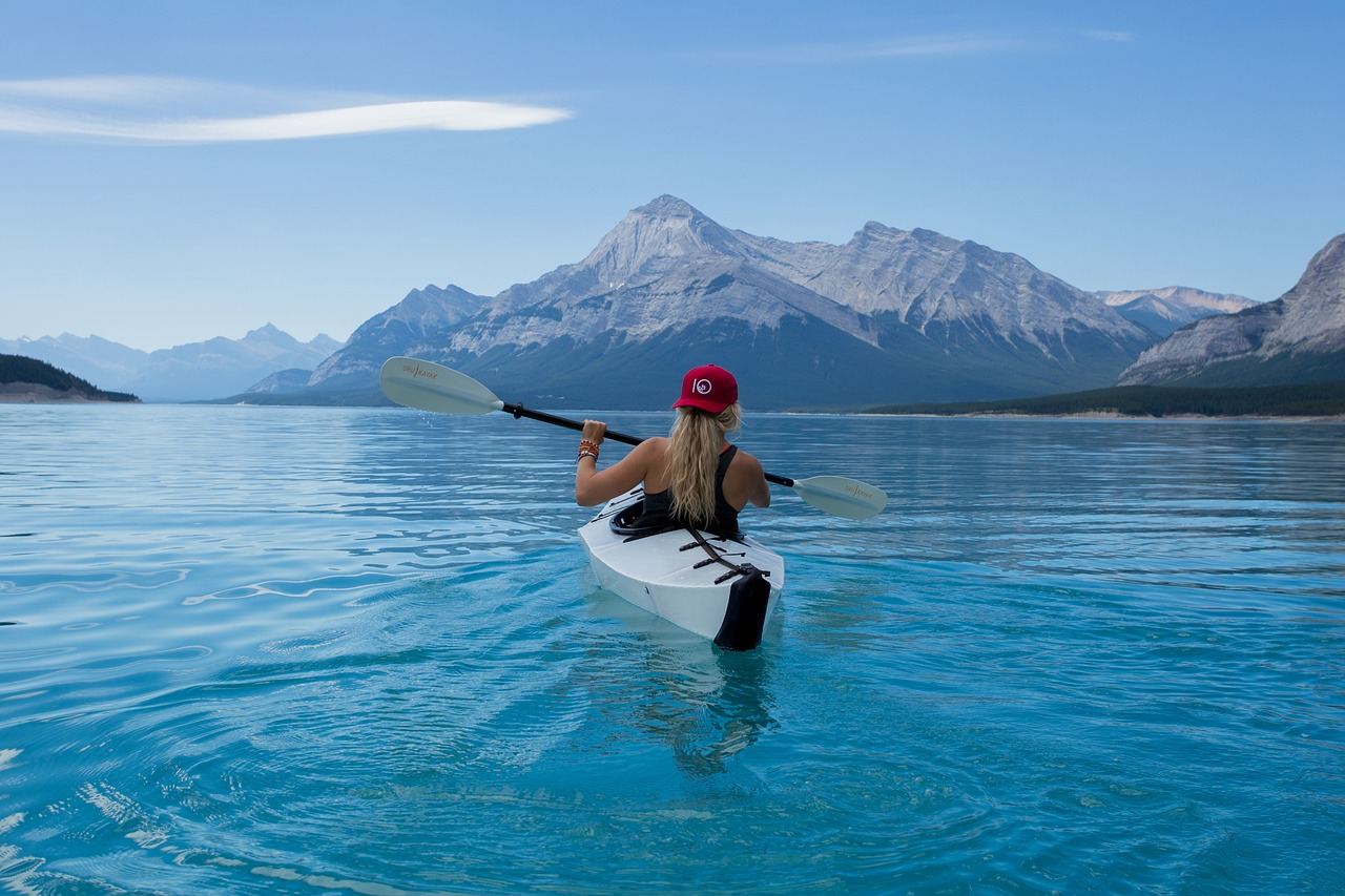 A kayaker paddles in clear blue water, exploring nature while considering if canoe racing is for them.