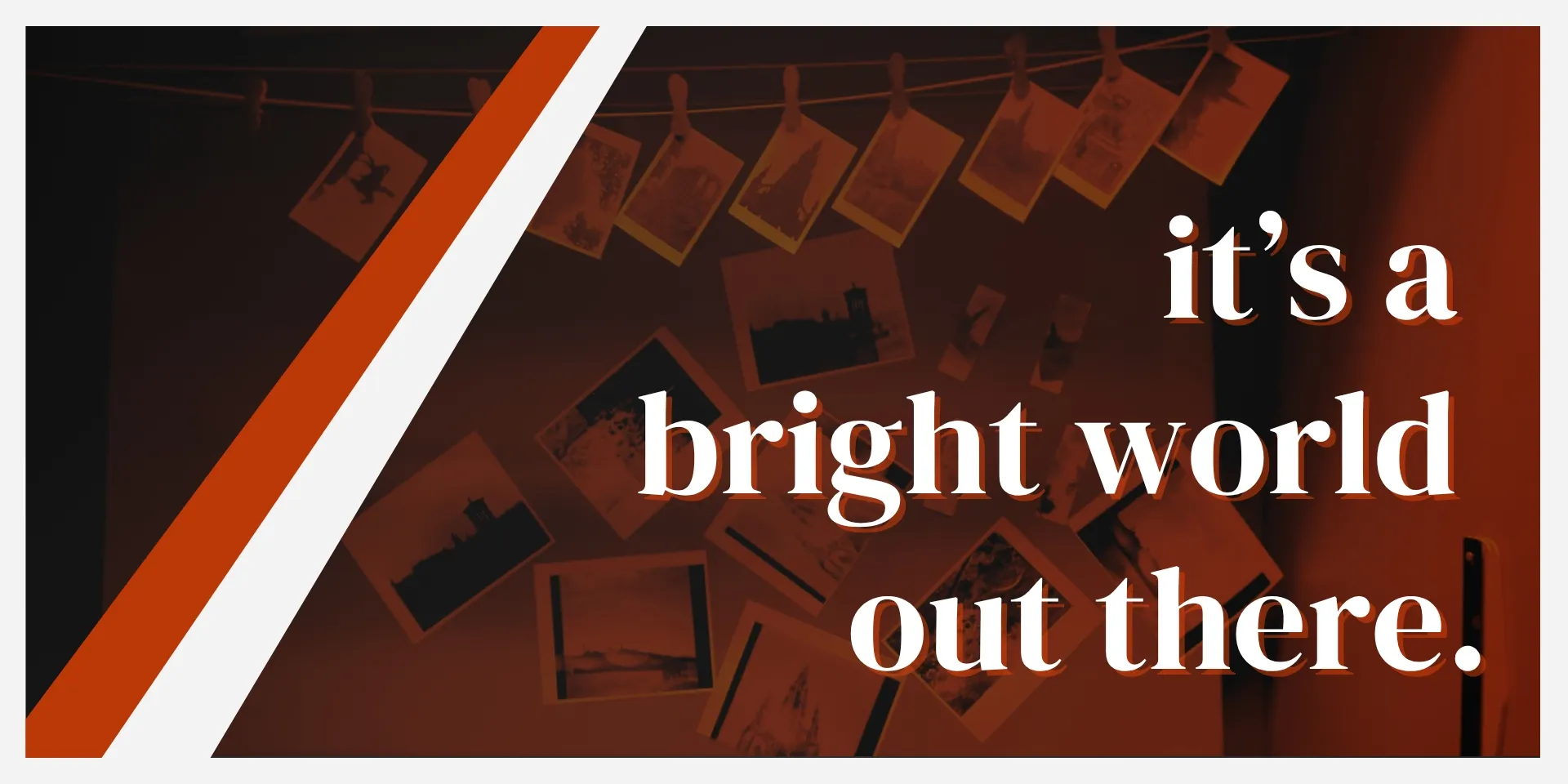 A darkroom showcasing photographs hanging on a line to dry with a title in front.