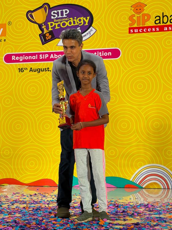 A proud student collecting their trophy on the SIP Prodigy stage.