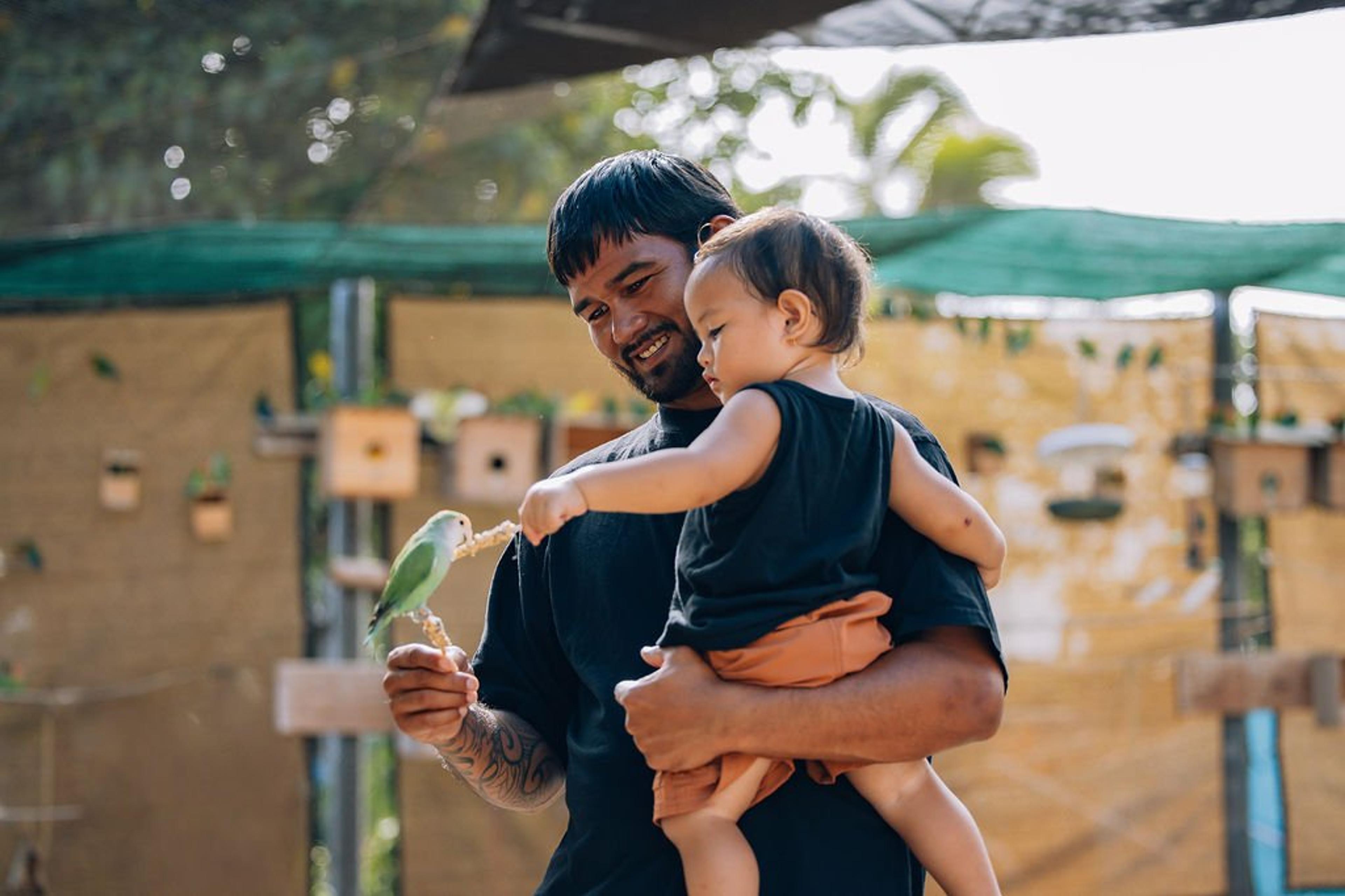 A father and son with a lovebird at Hale Manu