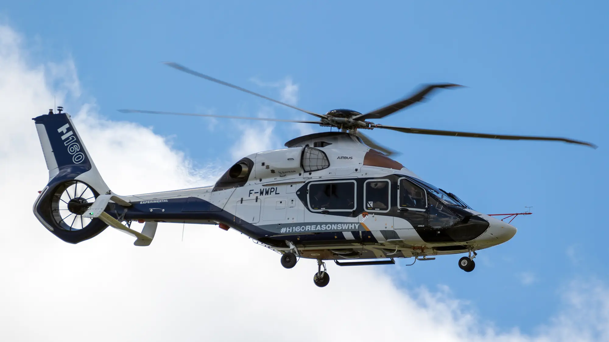 Elicottero Airbus H160 in volo con cielo sereno sullo sfondo.