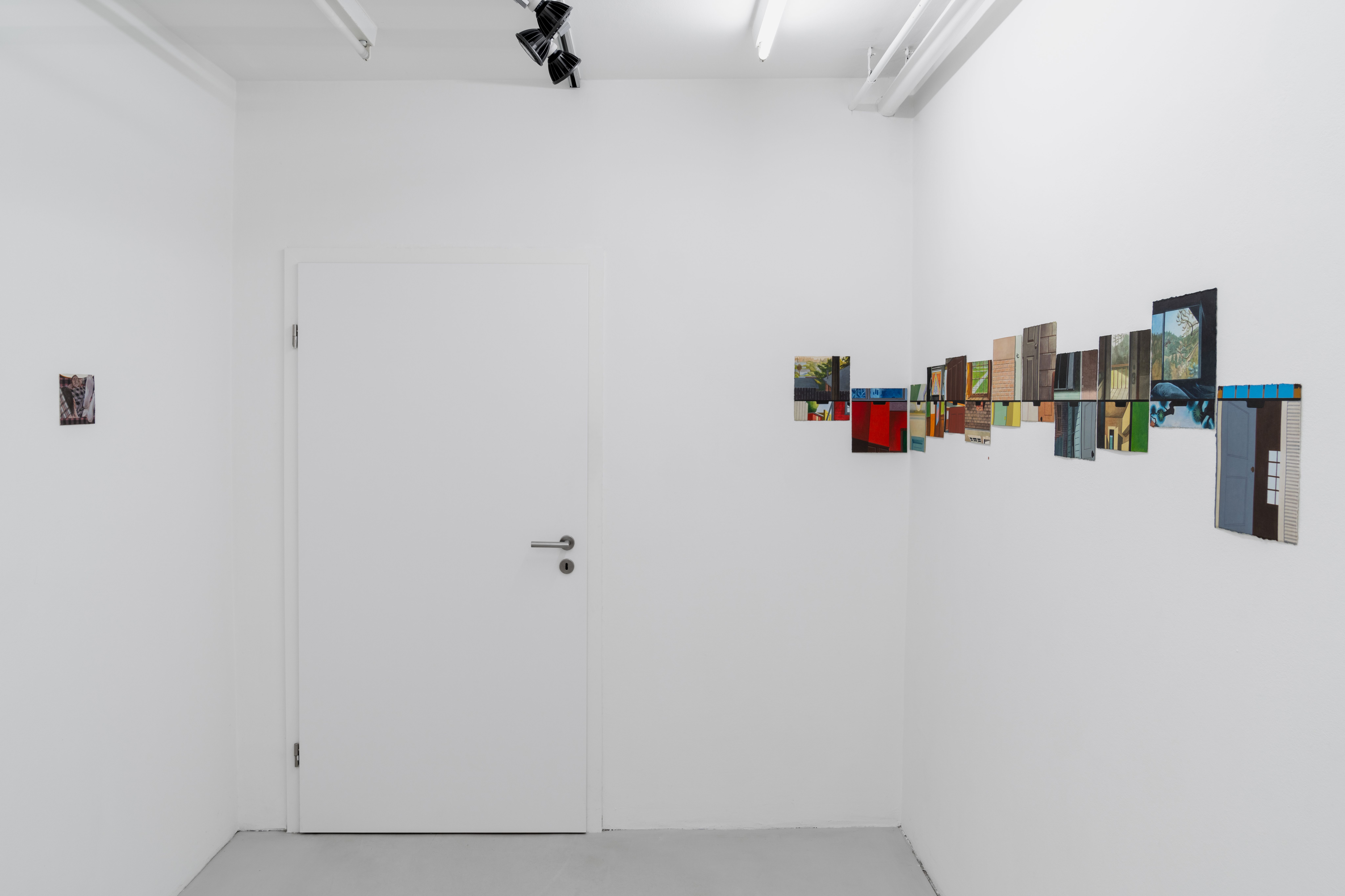 a row of small watercolours hung on a white gallery wall