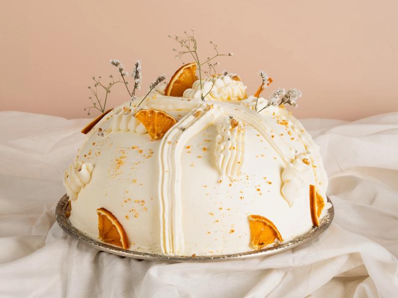 Torta de crema y naranja fotografiada sobre fondo liso para menú de delivery