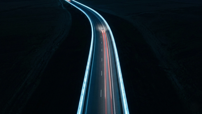 Abstract illustration of AI systems driving along a highway with digital guardrails and safety barriers