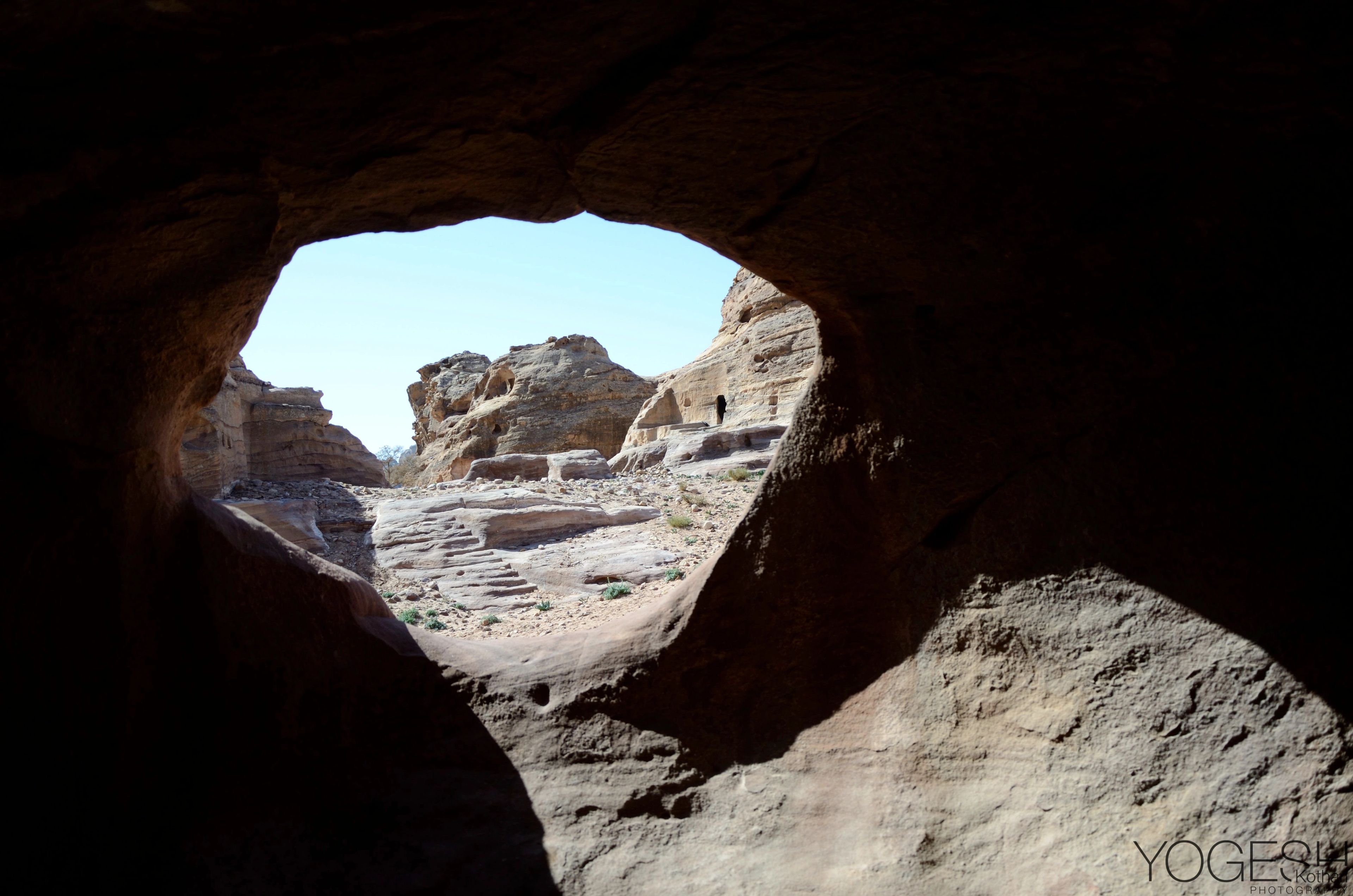 Petra’s sandstone landscape seen through the arched mouth of a cave
