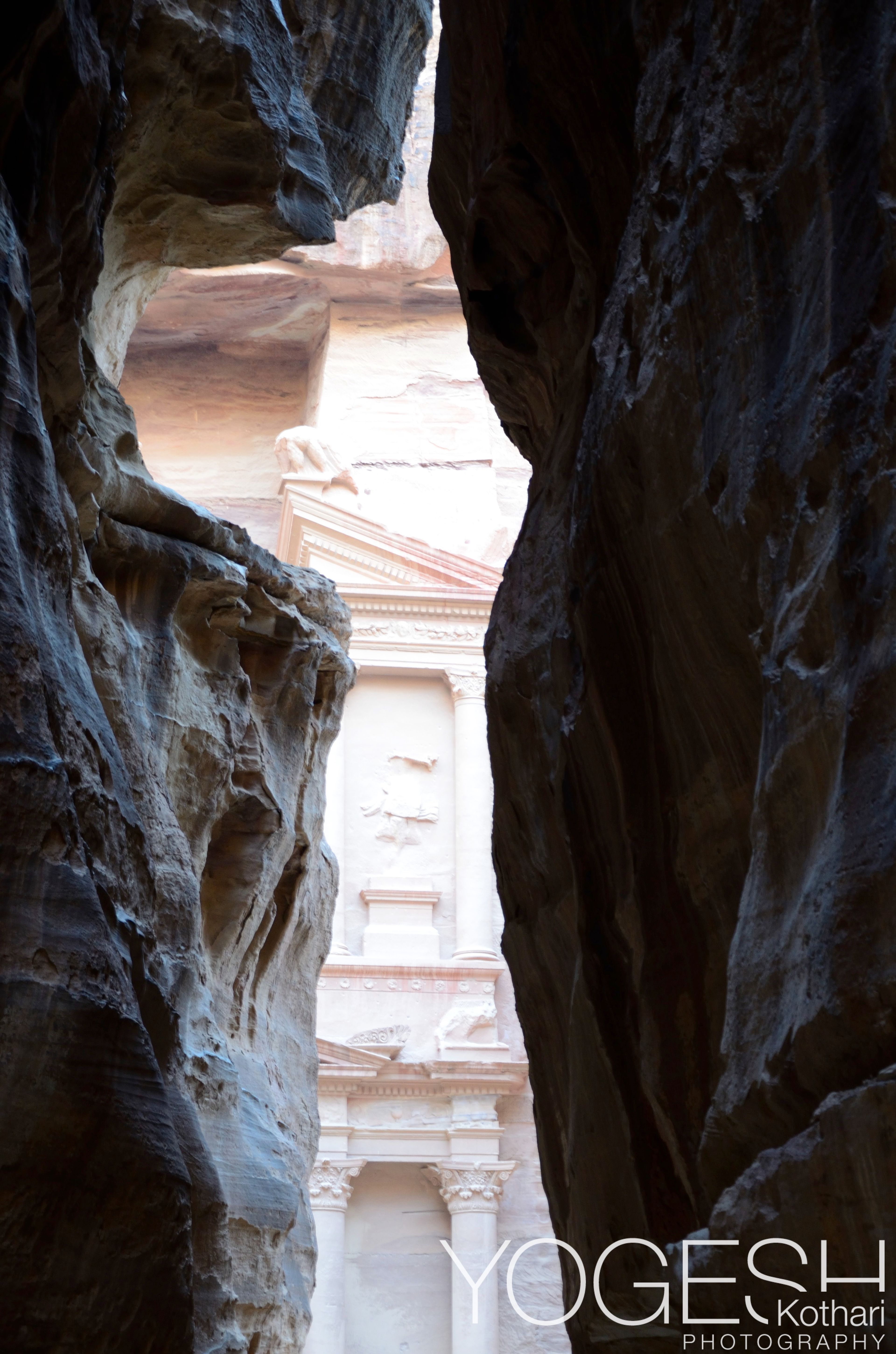 The Treasury in Petra glimpsed through the narrow rock walls of the Siq