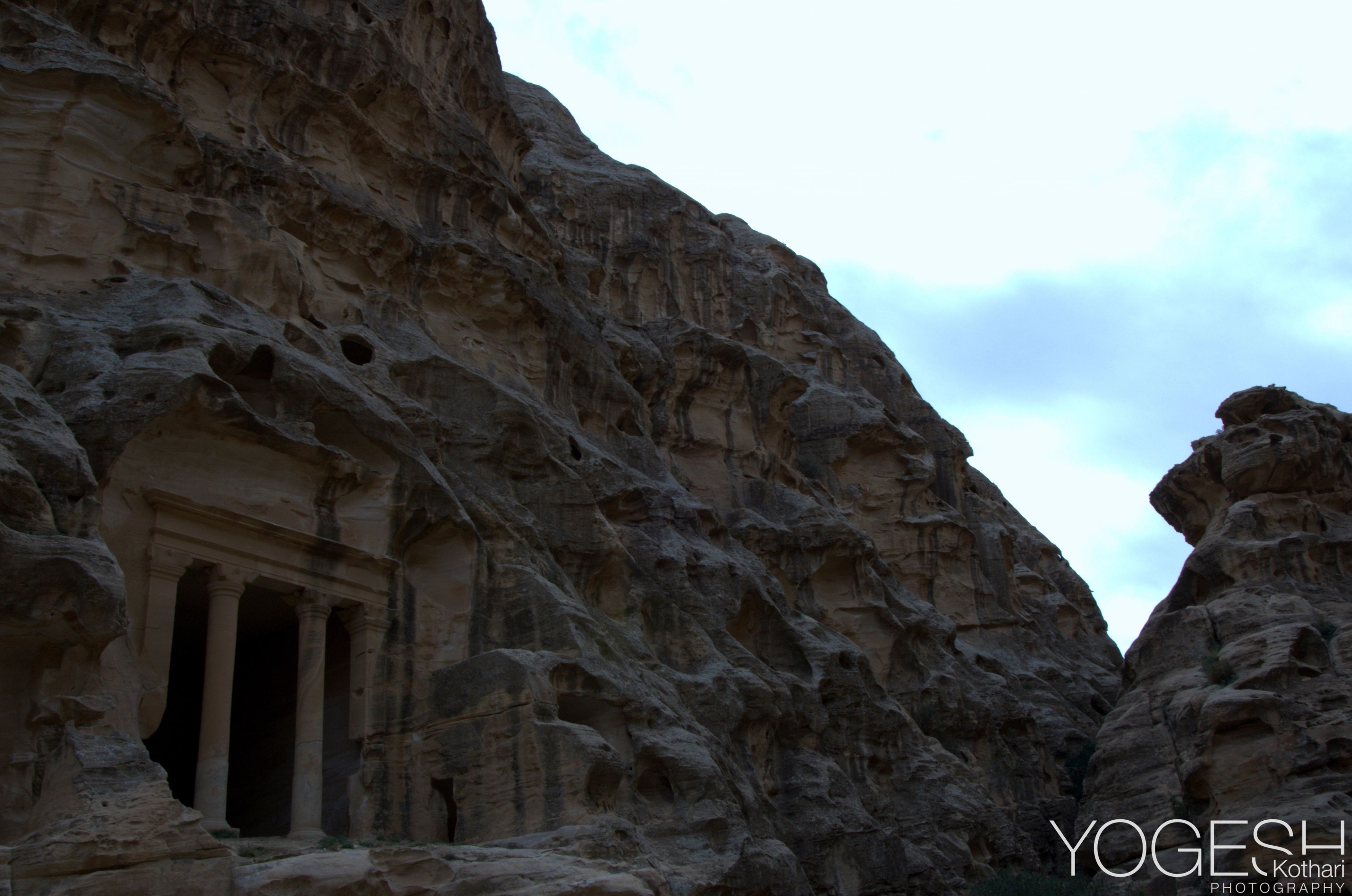 Columned tomb facade carved into a sandstone cliff in Petra