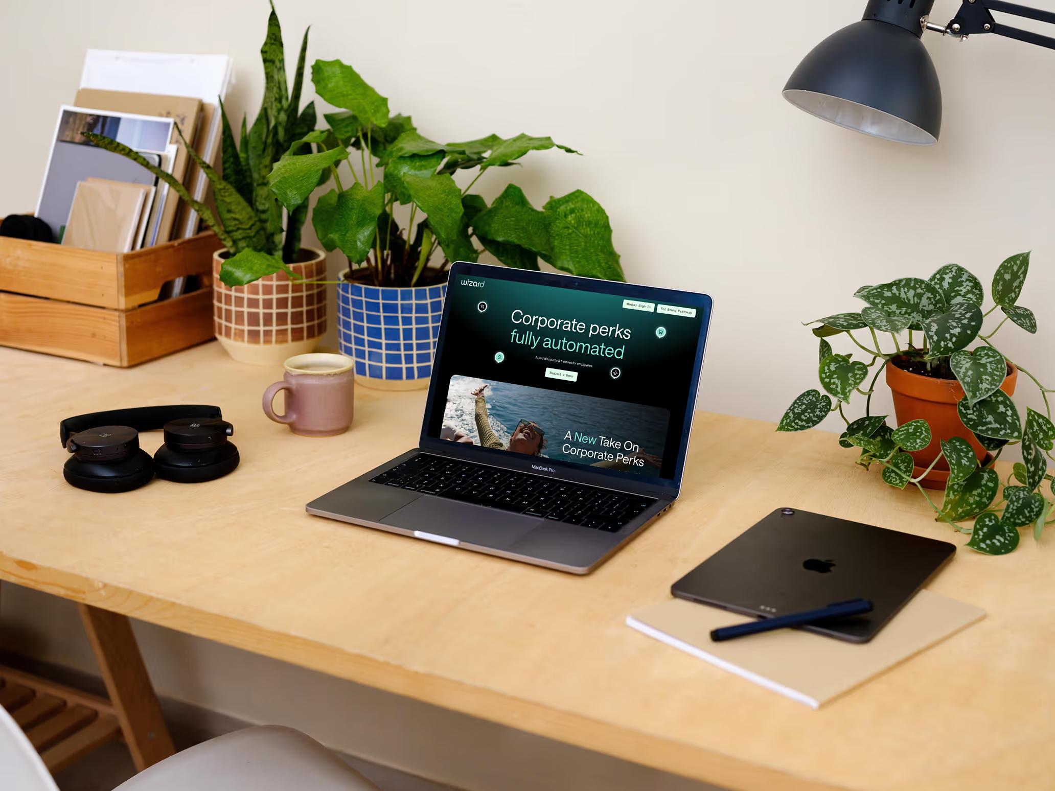 Wizard Perks homepage mockup on a MacBook showing Corporate Perks Fully Automated headline