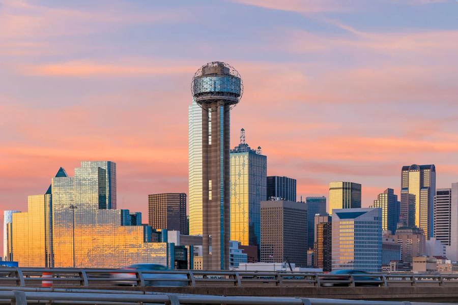 Reunion Tower against an orange dusk sky in Downtown Dallas
