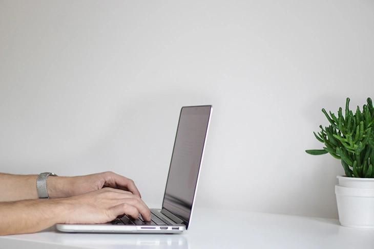 a person writing a blog on an apple laptop