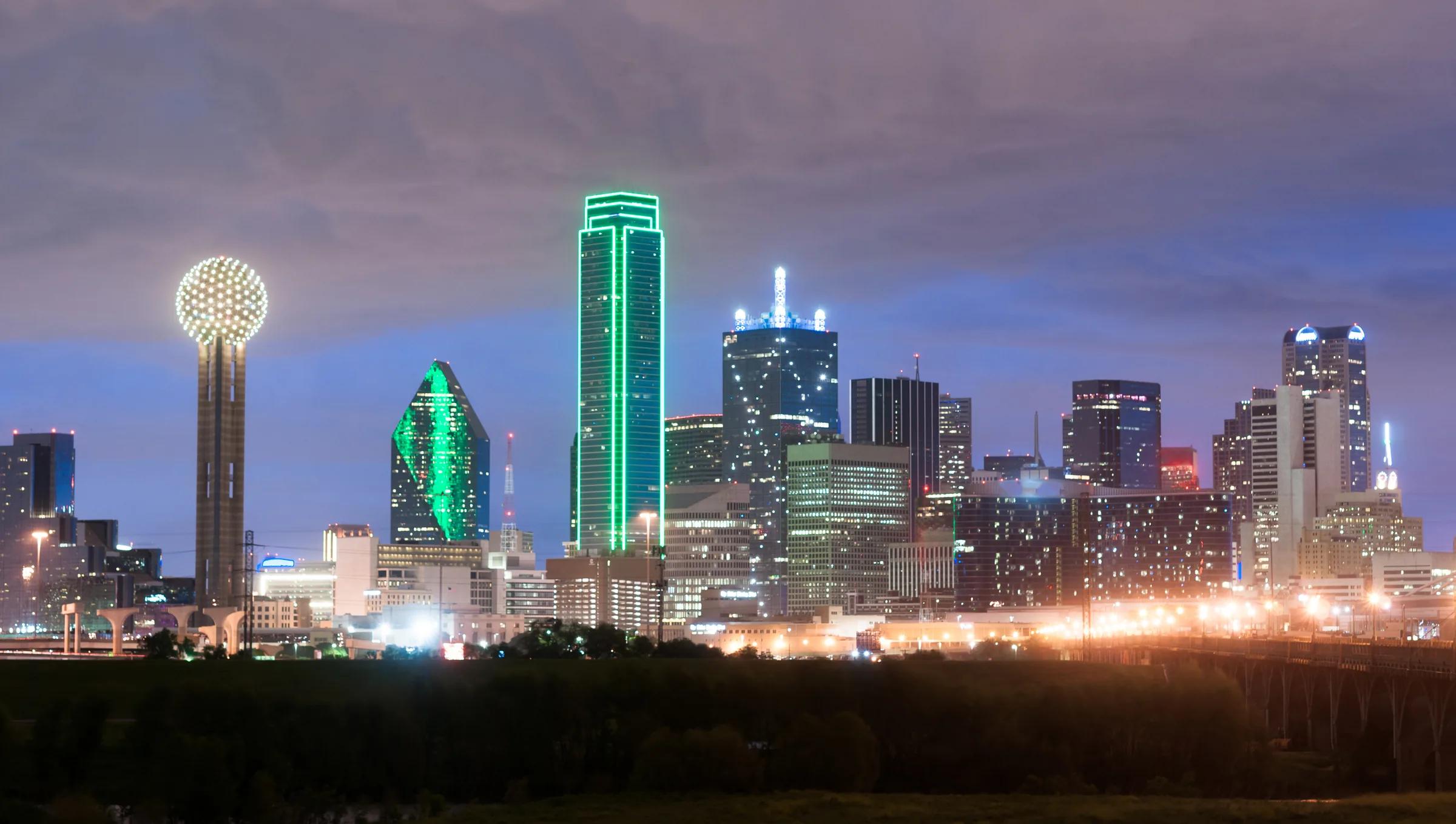 The Downtown Dallas skyline at night, seen from a distance