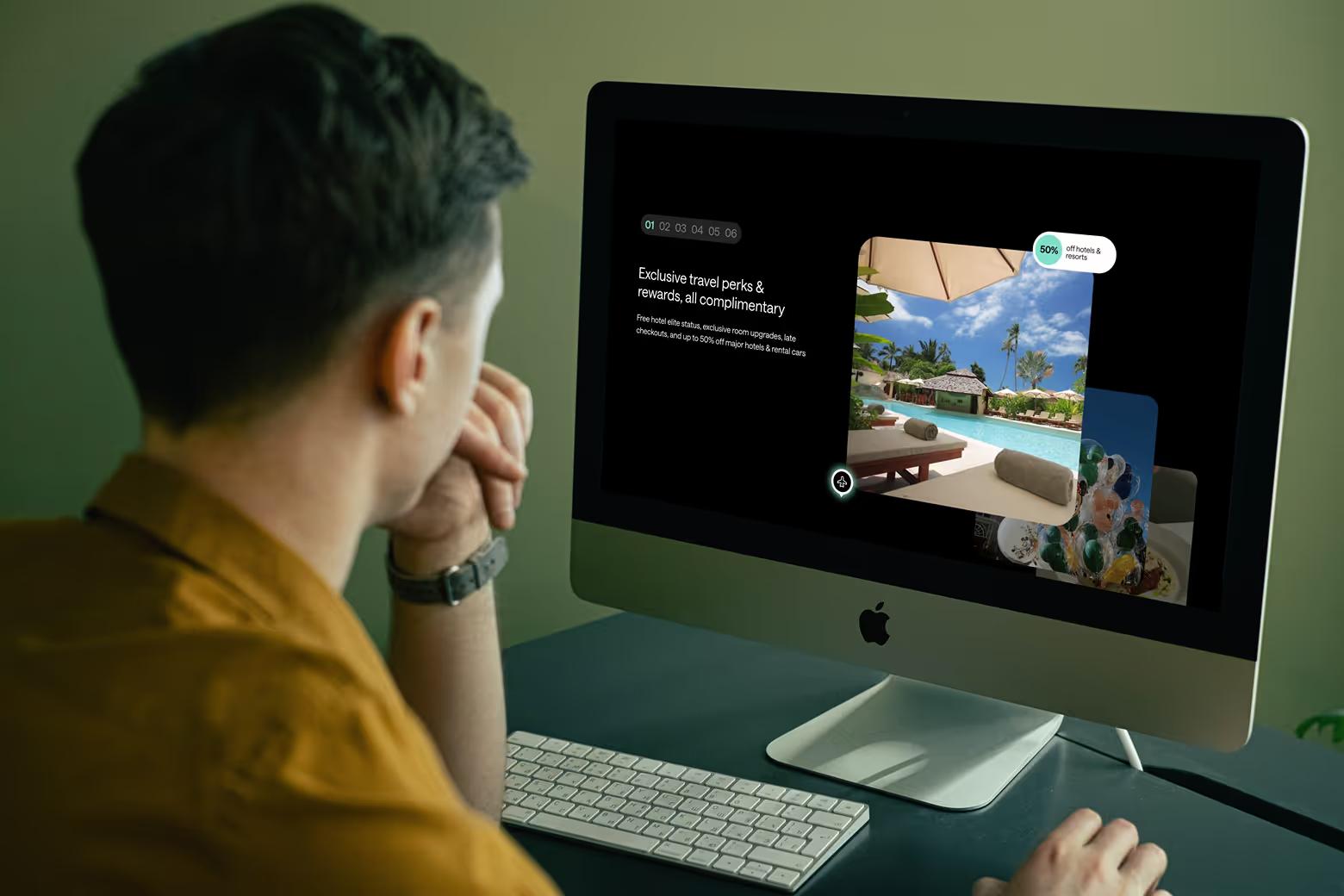 Man viewing Wizard Perks exclusive travel perks section on iMac at desk