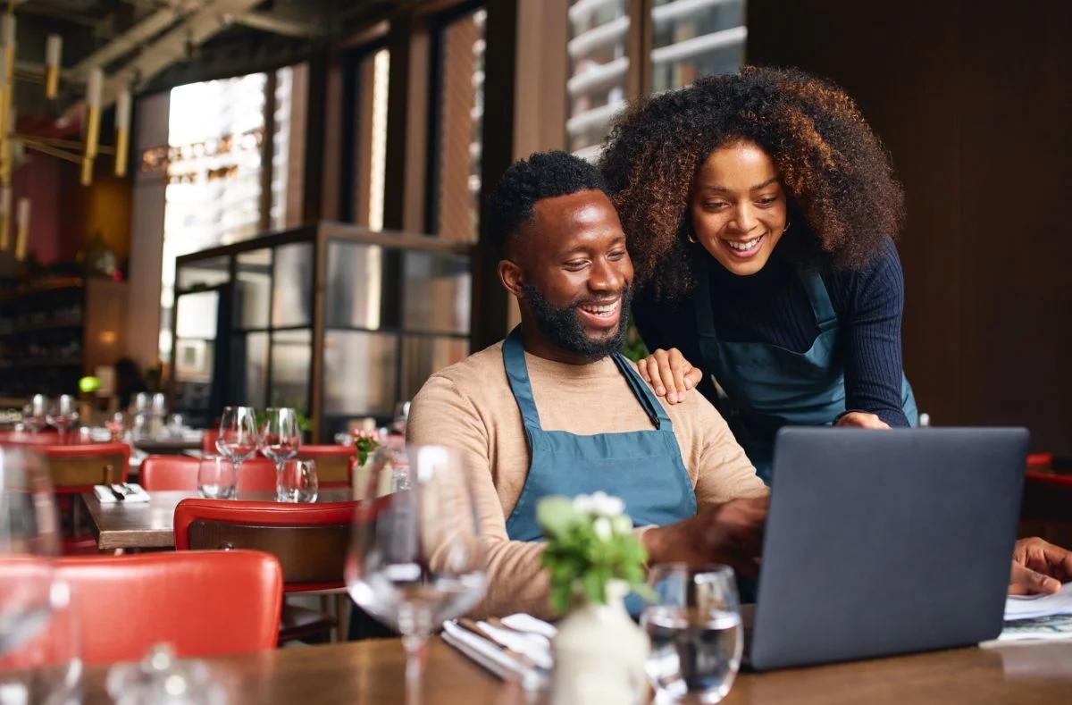 business owners looking at computer after good website design helped them succeed